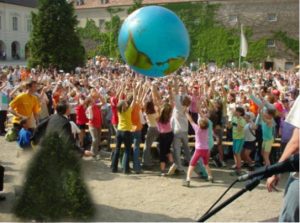 Viele Kinder spielen mit einem großen Erdball-Luftballon